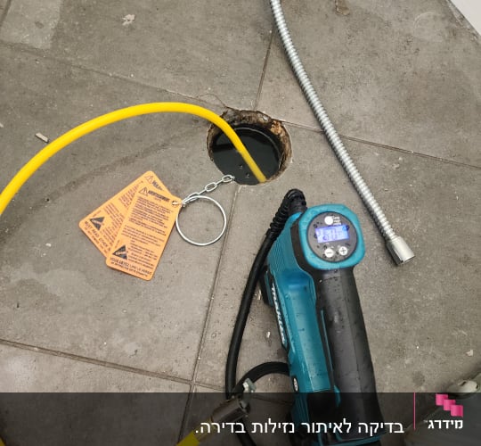 צינור צהוב מחובר לכלי עבודה על רצפה אפורה